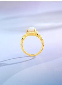 Close-up of vintage gold sterling silver ring with white opal and cubic zirconia halo
