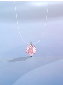 Macro detail of pink octagon cut gemstone pendant on invisible fishline necklace chain