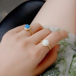 925 silver rings with blue and white opal stones and gold chain-style band on hand