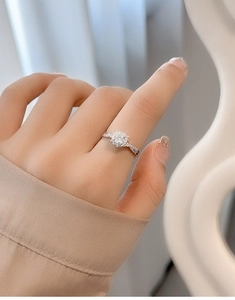 Close-up of S925 silver heart ring with a large round diamond on a woman hand