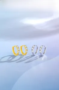 Macro shot of gold and silver S925 sterling silver hoop earrings with 3 micro-set zircons