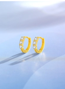 Close-up of gold S925 silver hoop earrings featuring three sparkling zircon stones