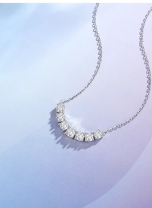 Macro shot of curved S925 sterling silver necklace featuring seven radiant white gemstones