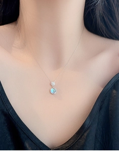 Close-up of moonstone heart necklace on model collarbone with silver chain
