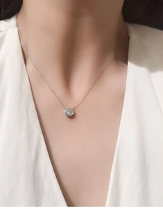 Close-up of S925 sterling silver D color moissanite pendant worn by a model