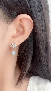 Close-up of S925 silver daisy flower stud with iridescent moonstone teardrop pendant