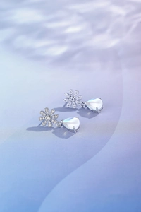Detailed macro view of S925 silver daisy earrings with pear-shaped moonstone pendants