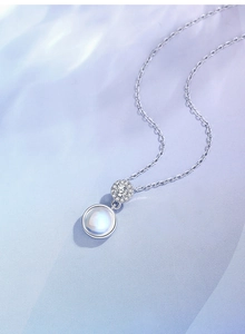 Macro detail of S925 sterling silver moonstone heart necklace with diamond pavé accents