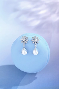 Detail of daisy flower earrings with S925 silver, sparkling zircons and teardrop moonstone
