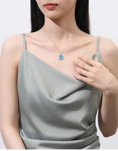 Modell mit rechteckigem meerblauem Anhänger und funkelnden kleinen Mikropavé-Kristallen