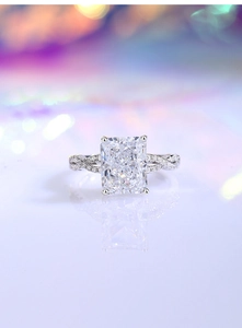 Vista macro di un anello di fidanzamento in moissanite taglio radiant con fascia intrecciata