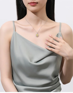 Detail einer Halskette mit gelbem Asscher-Schliff-Anhänger und Diamant-Halo an Model