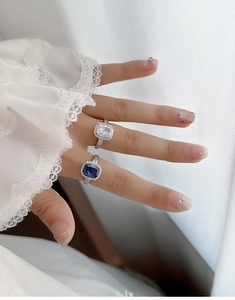 Close-up of square cut rings in white and sapphire blue with micro-paved details