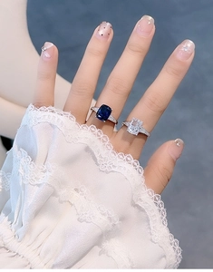 Close-up of S925 silver rings with blue cushion cut stone and sparkling pavé diamonds