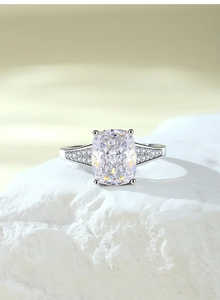 Dettaglio anello in argento con pietra taglio princess e zirconi laterali scintillanti