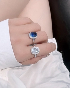 Close-up of S925 silver halo rings featuring large cushion cut blue and white stones