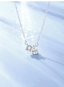 Macro detail of S925 silver necklace with round and pear cut moissanite pendants