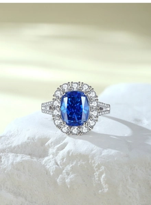 Macro detail of royal blue radiant cut sapphire ring with halo and split shank pave