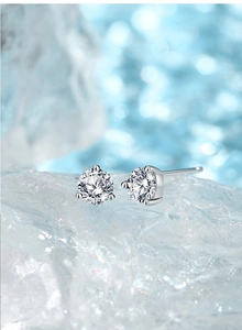 Detailed view of 925 sterling silver three-prong earrings with brilliant cut cubic zirconia