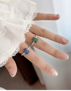 Macro shot of S925 silver rings with radiant blue and green sapphire cushion cut stones