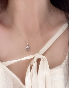 Close-up of S925 silver necklace featuring a pink heart cat claw pendant on a model