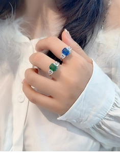 Close-up of S925 sterling silver rings with emerald-cut green and royal blue sapphires