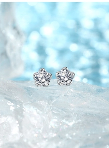Macro shot of 925 silver five-claw flower stud earrings with brilliant zircon on ice