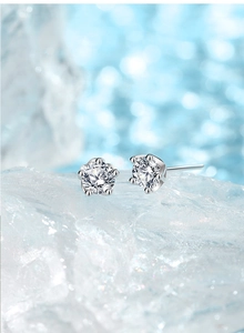 Detailed view of 5-claw plum blossom moissanite studs on crystal ice block background