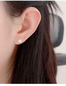 Close-up of minimalist S925 silver bubble stud earrings with round moissanite on ear
