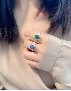 Detailed close-up of S925 silver rings with emerald cut sapphire and green gemstone