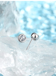 Macro view of S925 sterling silver moissanite stud earrings on ice crystal background