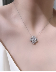 Detail of a sparkling S925 sterling silver four-leaf clover pendant on a delicate chain