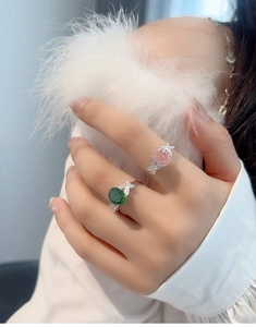 Close-up of S925 silver rings with green and pink gems and sparkling diamond bows