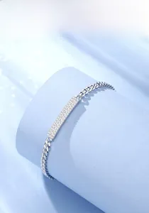 Macro detail of silver link chain with crystal encrusted bar on blue pedestal