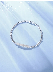 Detail of silver Cuban link bracelet featuring a rectangular bar paved with white zircons