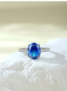 Macro shot of S925 sterling silver ring with oval royal blue sapphire and side diamonds