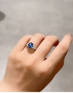 Close-up of S925 sterling silver ring with blue sapphire and butterfly diamond accents