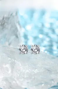 Dettaglio macro di orecchini a lobo in argento 925 e moissanite su cubetti di ghiaccio