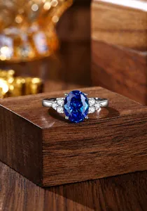 Macro-opname van een ovale koningsblauwe saffierring met diamanten op een houten blok