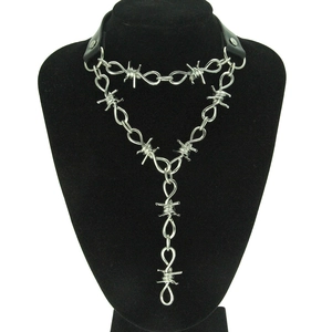 Detail of punk leather choker and silver thorn chain necklace on a black mannequin