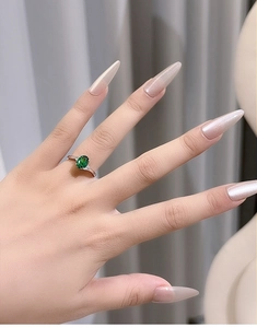 Close-up of elegant S925 silver ring featuring an oval green emerald and side diamonds