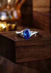 Detailopname S925 zilveren ring met blauwe saffier en zijdelingse accentstenen op hout