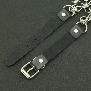 Close-up of black punk leather choker with silver metal thorn chain and buckle detail