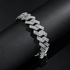 Détail de la gourmette cubaine argentée ornée de strass brillants sur support en cuir noir