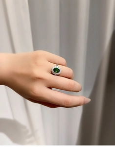 Macro detail of royal green sapphire ring with diamond halo in silver finish