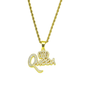 Macro detail of iced-out gold Queen pendant with crown and white crystal inlay