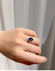 Close-up of radiant cut royal blue sapphire ring on hand featuring S925 silver band