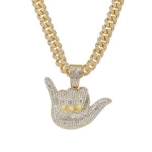 Détail du collier hip hop à chaîne cubaine dorée avec pendentif Shaka et strass