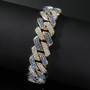 Hip hop gold Cuban link bracelet with iced out blue and white rhinestones on black stand