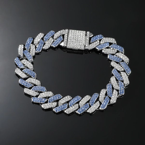 Detailed close-up of Cuban link bracelet with blue and white crystals on black surface